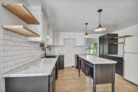 Modern kitchen interior with white tile backsplash and black cabinets